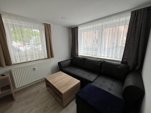 a living room with a couch and two windows at Ferienwohnung Ella in Marktoberdorf
