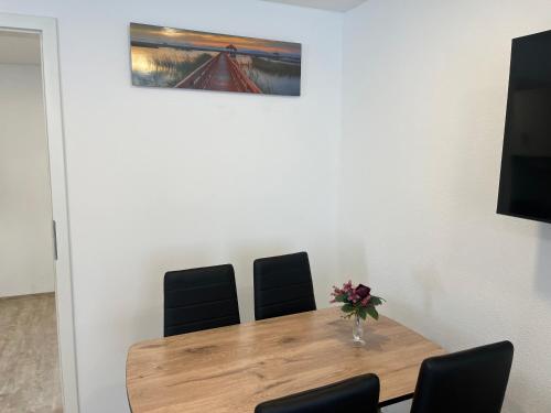 a dining room table with chairs and a vase of flowers at Ferienwohnung Ella in Marktoberdorf