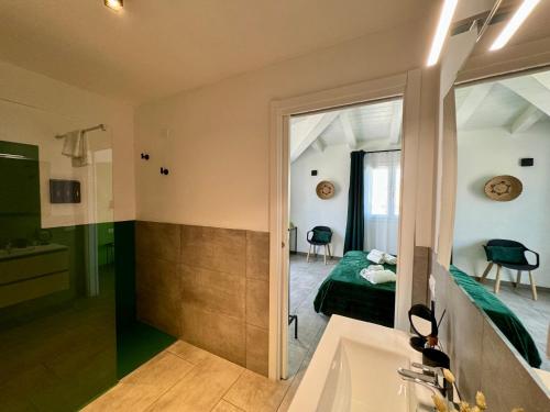 a bathroom with a sink and a bed and a mirror at Citroom - green city rooms in Olbia