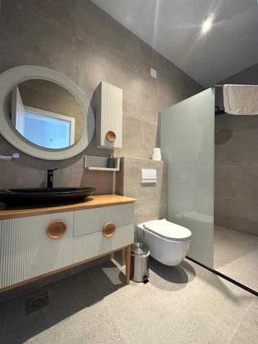 a bathroom with a toilet and a mirror at Pristina Select Apartments in Pristina