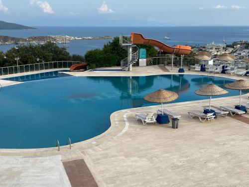 a large swimming pool with a water slide and umbrellas at Clup dedeman in Bodrum City