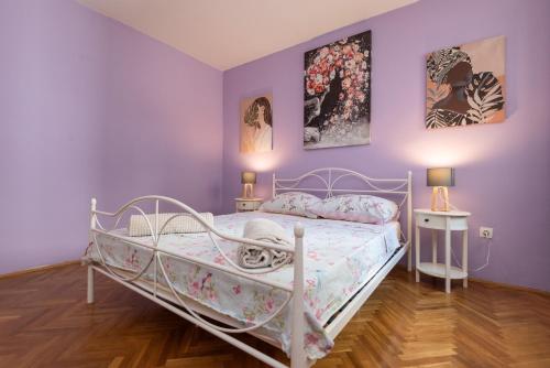 ein Schlafzimmer mit einem weißen Bett in einem Zimmer mit lila Wänden in der Unterkunft Spacious City Center apartment - 4 pax in Dubrovnik