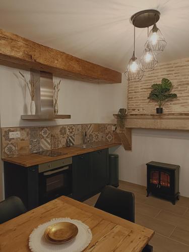 une cuisine avec une table en bois et un comptoir en bois dans l'établissement L'atelier Détente et Spa, à Caudrot