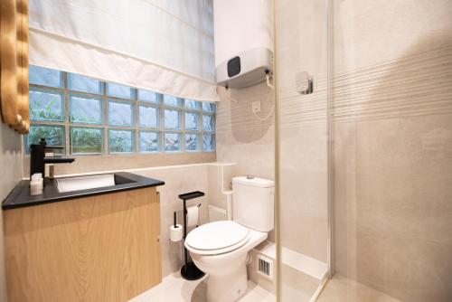 une salle de bain avec toilettes, lavabo et fenêtre dans l'établissement CIA - Beaurepaire, à Paris