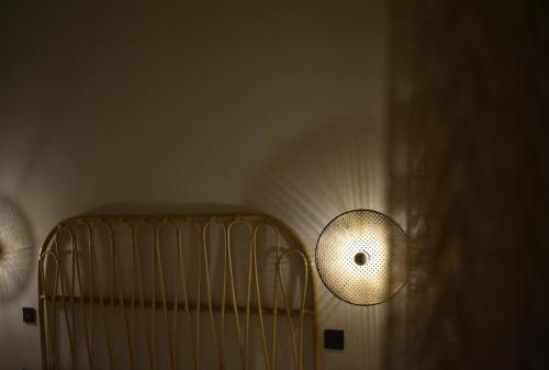 a room with a crib and a light on the wall at Kikkos Village House in Néa Koróni