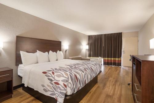 a hotel room with a large bed and a bathroom at Red Roof Inn Baltimore South Glen Burnie in Glen Burnie