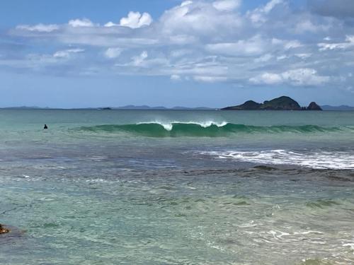 a person riding a wave in the ocean at Far North Panorama in Kaingaroa