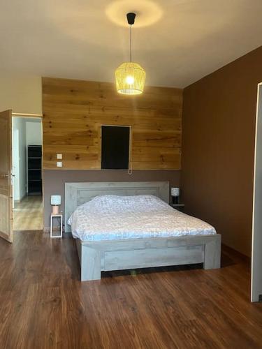 une chambre avec un lit dans une pièce aux murs en bois dans l'établissement Logement spacieux en pleine nature, à Saint-Sauveur