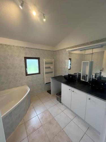 une salle de bain avec une baignoire et un lavabo dans l'établissement Logement spacieux en pleine nature, à Saint-Sauveur