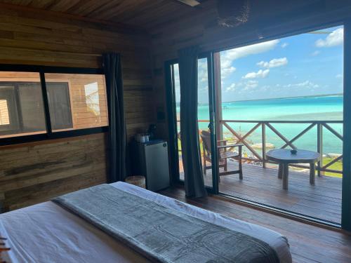 a bedroom with a bed and a view of the ocean at Blue Caribe Bacalar Front Lagoon in Bacalar