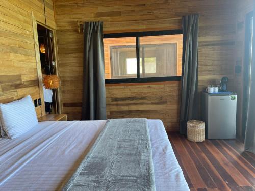 a bedroom with a large bed with a window at Blue Caribe Bacalar Front Lagoon in Bacalar