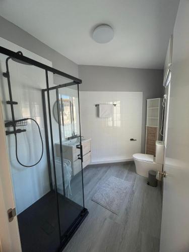 a bathroom with a glass shower and a toilet at Casa do Sol in O Grove