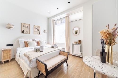 une chambre blanche avec un grand lit et une table dans l'établissement CIA - Eiffel tower, à Paris