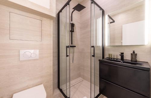 une salle de bain avec une douche en verre et un lavabo dans l'établissement CIA - Eiffel tower, à Paris