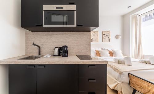 - une cuisine avec un évier et un four micro-ondes au-dessus d'un comptoir dans l'établissement CIA - Eiffel tower, à Paris