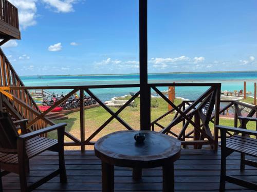 a balcony with two chairs and a table and the ocean at Blue Caribe Bacalar Front Lagoon in Bacalar