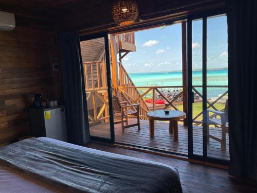 a bedroom with a bed and a view of the ocean at Blue Caribe Bacalar Front Lagoon in Bacalar