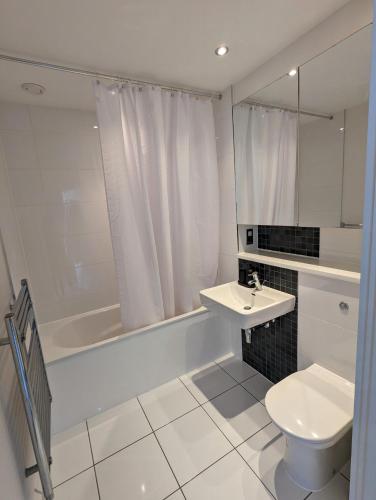 a white bathroom with a toilet and a sink at Number 43 Elite Apartment - Top Floor - Free Parking in Hemel Hempstead