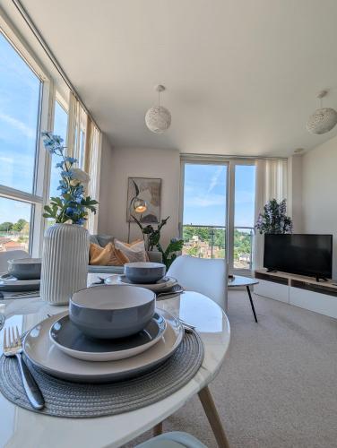 a living room with a table with plates on it at Number 43 Elite Apartment - Top Floor - Free Parking in Hemel Hempstead