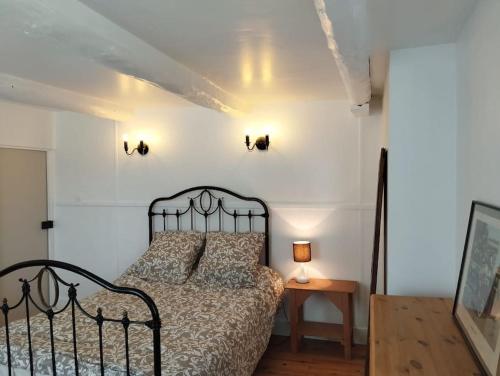 une chambre avec un lit et une table avec une lampe dans l'établissement Maison de campagne, cottage, à Saint-Genès-la-Tourette