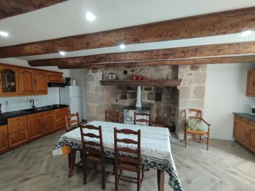 une cuisine avec une table et des chaises dans une pièce dans l'établissement Maison de campagne, cottage, à Saint-Genès-la-Tourette