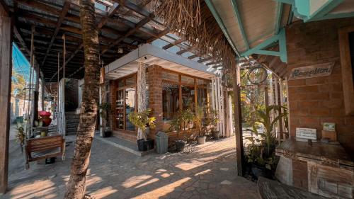 a building with a porch with potted plants in it at Coconut Dream in Gili Trawangan
