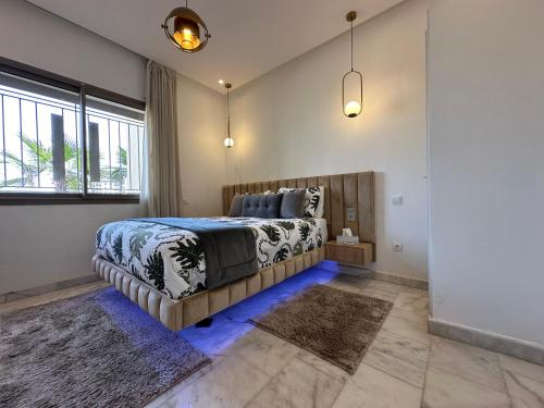 Airport Apartment Suite Casablanca FREE WIFI Modern Confort Calme في Derroua: غرفة نوم بسرير كبير مع اضاءة زرقاء