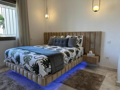 a bedroom with a large bed with a wooden headboard at Airport Apartment Suite Casablanca FREE WIFI Modern Confort Calme in Derroua