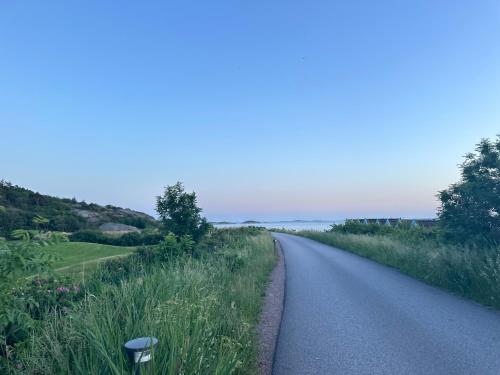 a road with grass and flowers on the side at Ground floor apartment near the sea, golf, lake, and forest in Hovås