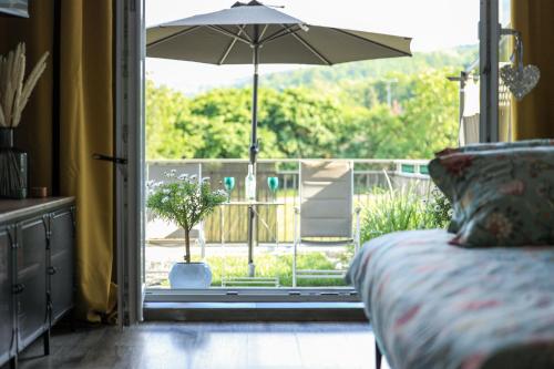 a bedroom with a bed and an open door with an umbrella at Apartament Komandorski przy Aquaparku in Reda