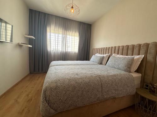 - une chambre avec un grand lit et une fenêtre dans l'établissement AeroChic, à Nouaceur