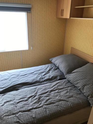 a bed in a bedroom with a window at Apartamenty i Domki WyDmy Międzywodzie in Międzywodzie