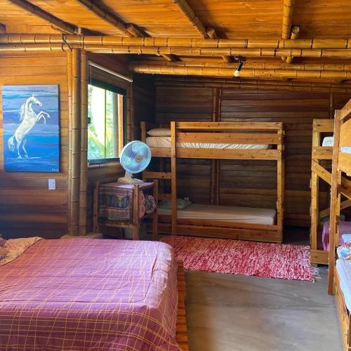 a bedroom with two bunk beds in a log cabin at Chalés Sitio Mangala in Itapeva
