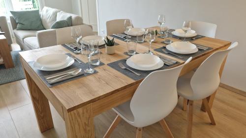 - une table à manger avec des assiettes et des verres à vin dans l'établissement Lac Plage et Ville 95 m2 a 100m du lac, 3 chambres, parking, à Annecy