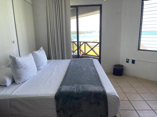 a bedroom with a bed with a view of the ocean at Blue Caribe Bacalar Front Lagoon in Bacalar