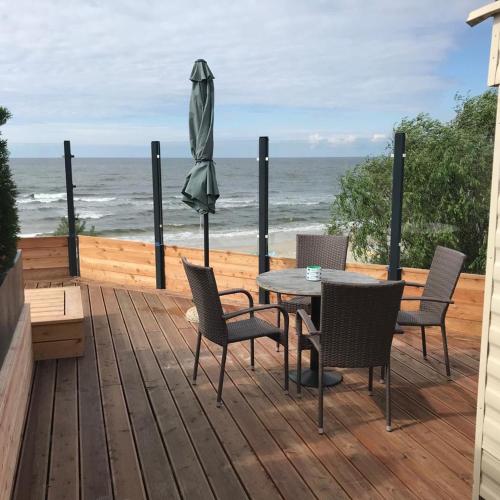 a patio with a table and chairs and an umbrella at Apartamenty i Domki WyDmy Międzywodzie in Międzywodzie