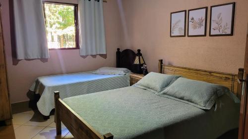 a bedroom with two beds and a window at Chácara Alto do Vale in Bueno Brandão