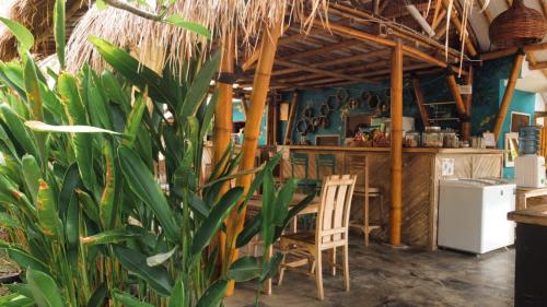 a restaurant with a table and chairs and a plant at Gili Matiki in Gili Air