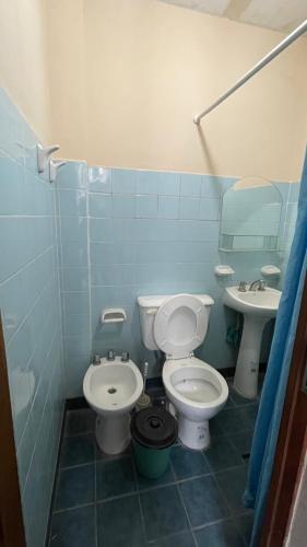 a blue bathroom with a toilet and a sink at Los alamos in Humahuaca