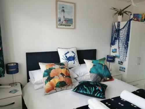 a bedroom with a bed with colorful pillows on it at The Blue Crab in Bournemouth in Bournemouth