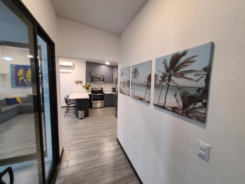 a hallway with pictures of palm trees on the wall at Villa Elenita - Pura Vida in Parrita