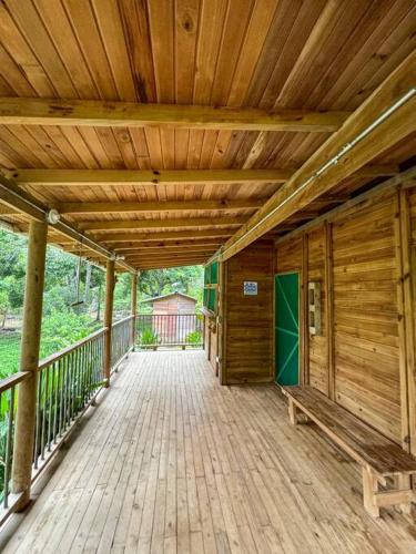 a wooden porch with a bench on a wooden deck at Alma Viajera Sapzurro in Acanti