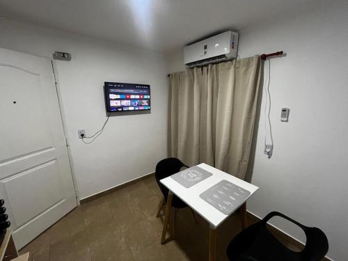 Cette chambre dispose d'une table et d'une télévision murale. dans l'établissement hospedaje LH E a 15 minutos del aeropuerto ezeiza, à Ezeiza