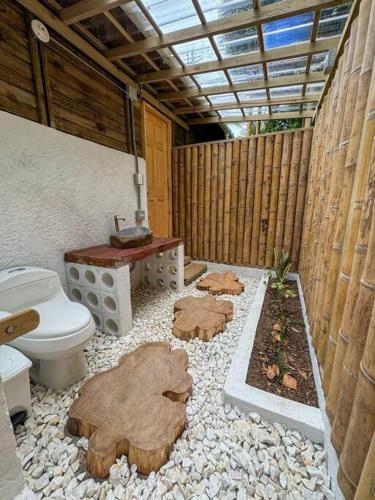 a bathroom with a toilet and a wooden fence at Alma Viajera Sapzurro in Acanti