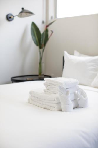 a pile of towels sitting on a bed at Abpopa Hillcrest in San Diego