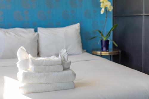 a pile of towels sitting on top of a bed at Abpopa Hillcrest in San Diego
