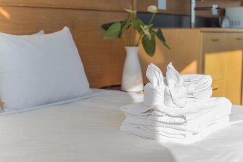 a pile of towels sitting on a bed with a laptop at Abpopa Hillcrest in San Diego
