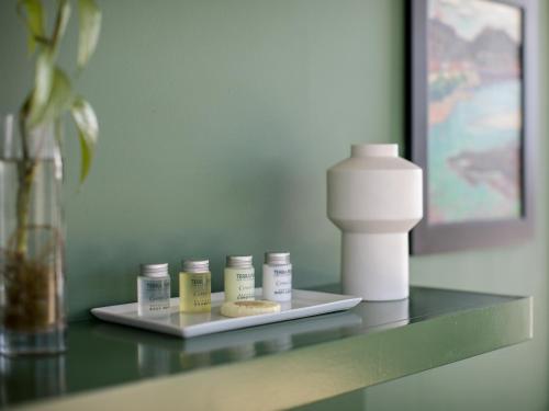 a shelf with four bottles of pills and a bottle of sunscreen at Abpopa Hillcrest in San Diego