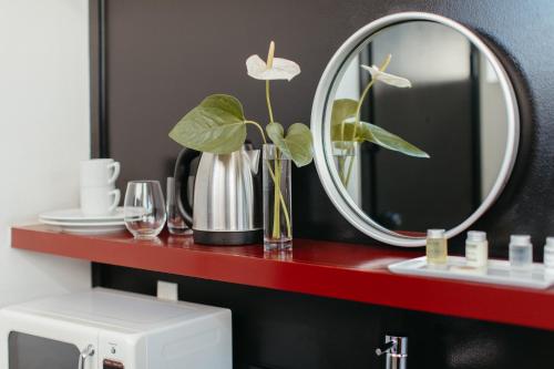 a red shelf with a mirror above a toilet at Abpopa Hillcrest in San Diego