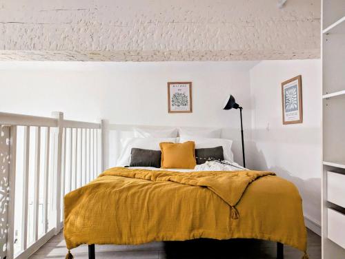 1 dormitorio con 1 cama con manta amarilla en L'escale secrète - Emplacement central premium, en Nimes